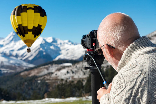 φωτογράφος στην κορυφή του βουνού με αερόστατο ζεστού αέρα - Φωτογραφία, εικόνα