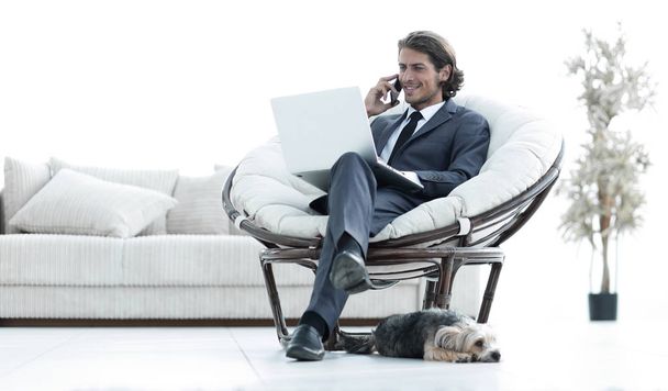 business man talking on a smartphone sitting in the living room - Foto, Bild