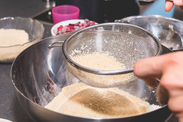 cook mixes and sieves almond powder in flour - Photo, Image