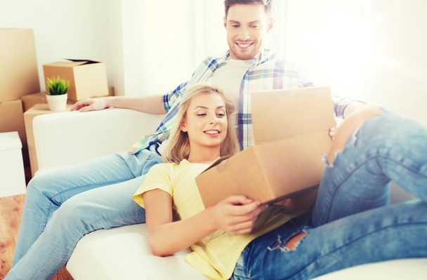 happy couple with big cardboard boxes at new home - Foto, afbeelding