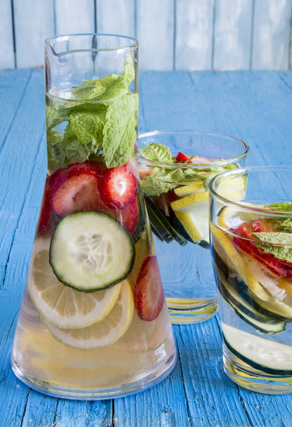 Dieet detox drankje met citroensap, aardbeien en komkommer. - Foto, afbeelding