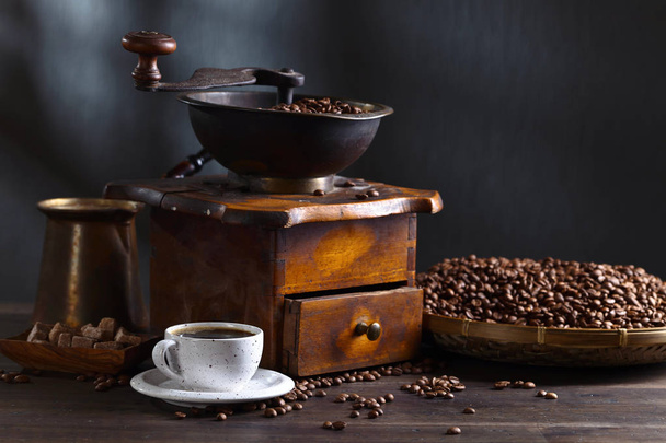 Taza de café negro, molinillo de café y frijoles asados
 - Foto, Imagen