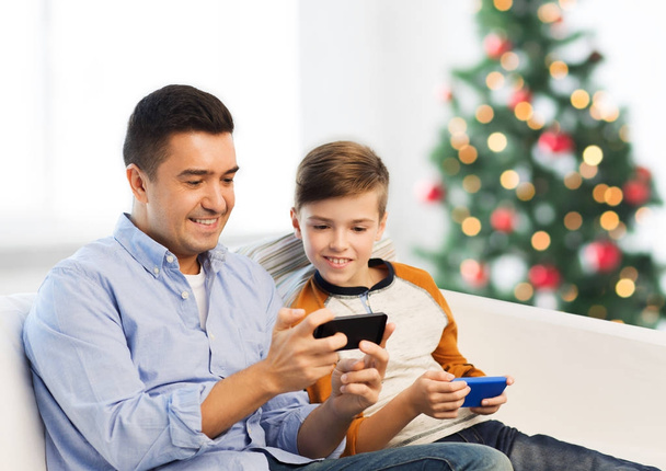 happy father and son with smartphones at christmas - Fotografie, Obrázek