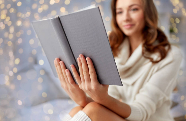happy young woman reading book in bed at home - Foto, Bild
