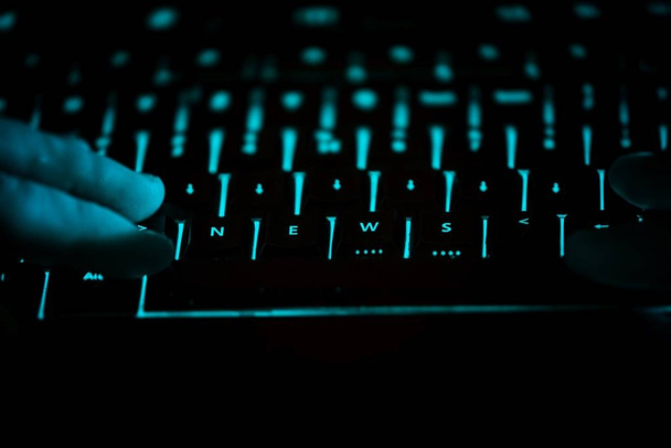 Nieuws - tekst op verlichte computertoetsenbord nachts - Foto, afbeelding