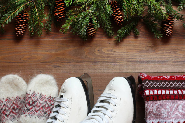The skates, sweater and mittens on a wooden background - Fotó, kép