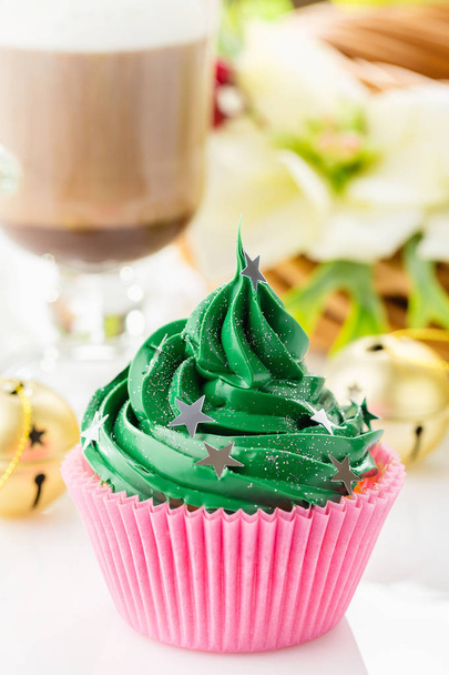Green christmas cupcake with star sprinkles in pink cup  - Photo, Image