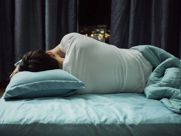 Homme dormant sur le lit la nuit
 - Photo, image