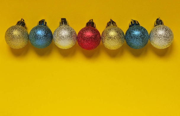  Цветной рождественский шар на желтом фоне с пробелами для текста
. - Фото, изображение