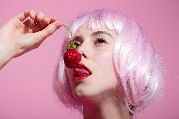 Woman in wig has no makeup on pink background - Foto, afbeelding