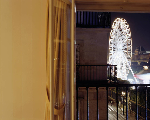 Uma vista da roda gigante e dos edifícios de um quarto de hotel em Paris
 - Foto, Imagem