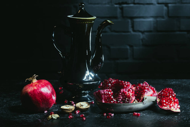 Black teapot and pomegranates   - Foto, Bild