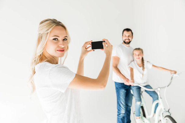 Kobieta fotografowania rodziny ze smartfonem - Zdjęcie, obraz