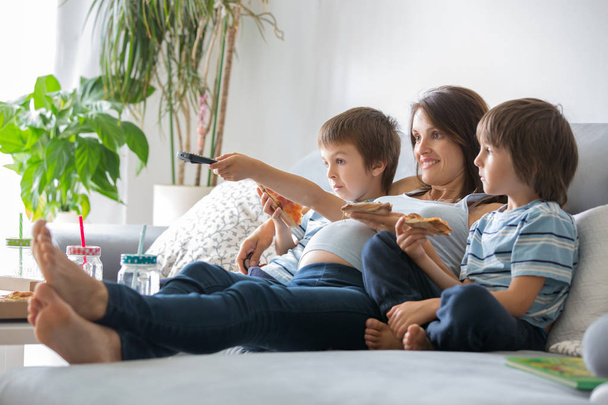 Happy young family, pregnant mother and two boys, eating tasty p - Foto, Bild