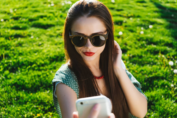 Woman doing selfie outside on a grass ,copyspace - Photo, image
