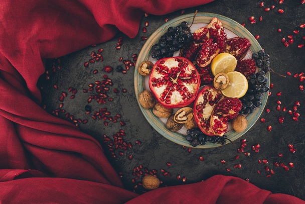 plate with pomegranates and grapes with lemons - Zdjęcie, obraz