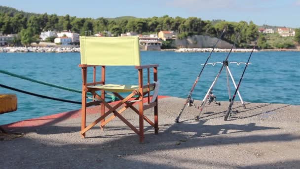 Kaç balıkçılık çubuklar ile rıhtımda boş ahşap katlanır sandalye - Video, Çekim