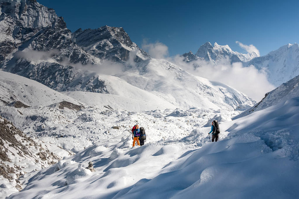 Trekkers crossing Gokyo glacier in Khumbu valley on a way to Eve - Фото, изображение