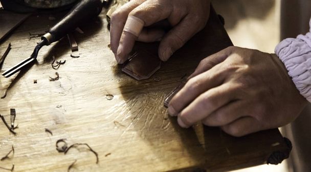 Homme sculptant du bois
 - Photo, image