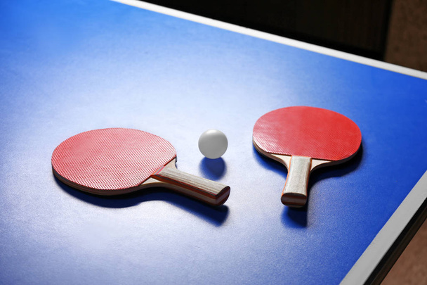Two ping pong rackets and ball on table - Valokuva, kuva