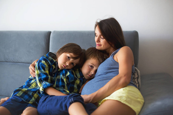 Portrait of beautiful pregnant mother, hugging her children - Valokuva, kuva