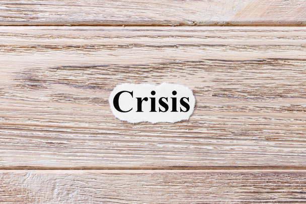 紙の上の単語の危機。コンセプトです。木製の背景上の危機の言葉 - 写真・画像
