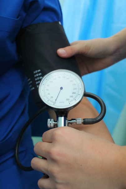 Медсестра вимірює кров'яний тиск пацієнта в надзвичайних ситуаціях
 - Фото, зображення