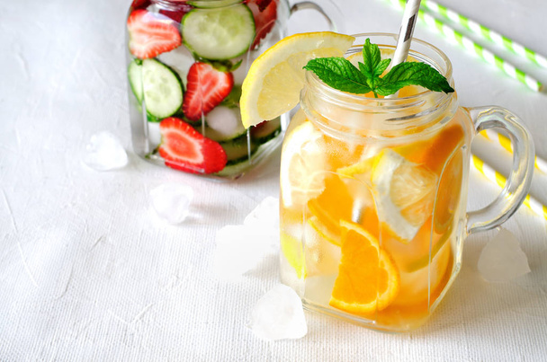 Summer refreshing iced drinks with orange, lemon, cucumber and strawberry on white background - Zdjęcie, obraz