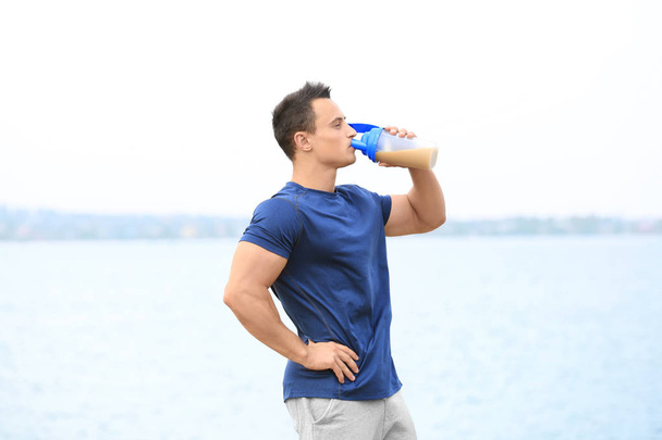 Handsome young man with protein shake  - Photo, Image