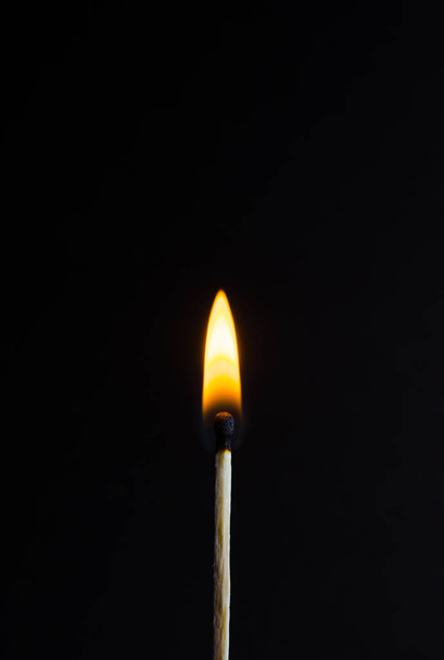 Photo of a burning match on a black background - Fotó, kép