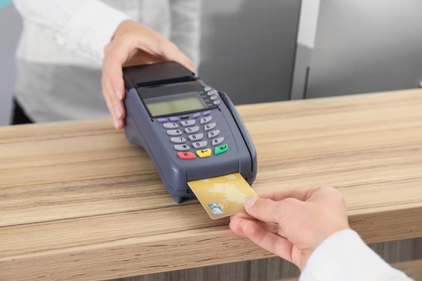 Femme utilisant un terminal bancaire pour le paiement par carte de crédit à l'intérieur
 - Photo, image