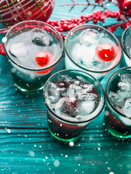 Χριστούγεννα κόμμα πράσινο ποτό με πάγο και κεράσι - Φωτογραφία, εικόνα