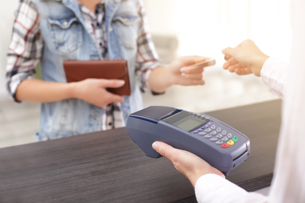 Femme utilisant un terminal bancaire pour le paiement par carte de crédit à l'intérieur
 - Photo, image
