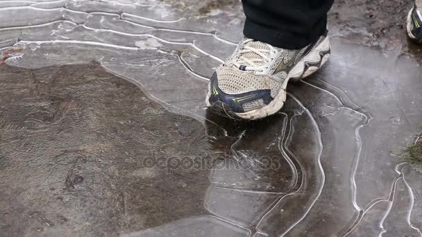Τα πόδια του ανθρώπου θρυμματισμό πάγου σε λακκούβα το χειμώνα - Πλάνα, βίντεο