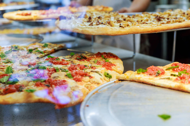 Beau pizzaiolo faire de la pizza à la cuisine dans la pizzeria. Pizza italienne fraîche dans la fenêtre de la pizzeria de New York
 - Photo, image