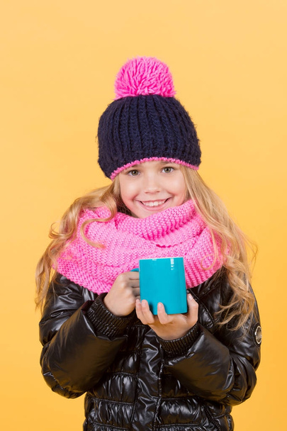 Girl in hat, pink scarf, black jacket with mug - Foto, imagen