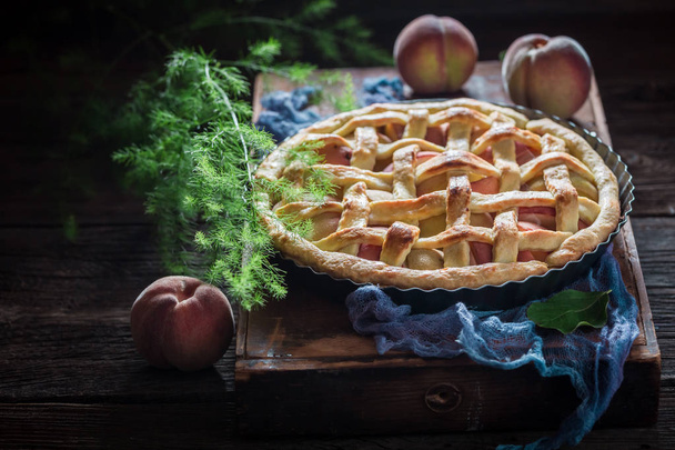 Tasty and hot tart with peaches on blue cloth - Foto, immagini