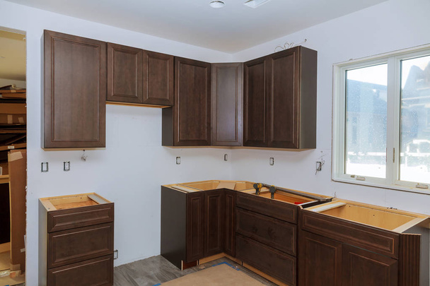 Aangepaste keukenkasten in verschillende stadia van de installatie base voor eiland in centrum - Foto, afbeelding