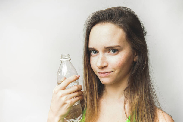 Fitness happy girl with bottle. beautiful long-haired girl holding a bottle of water - Foto, Imagem