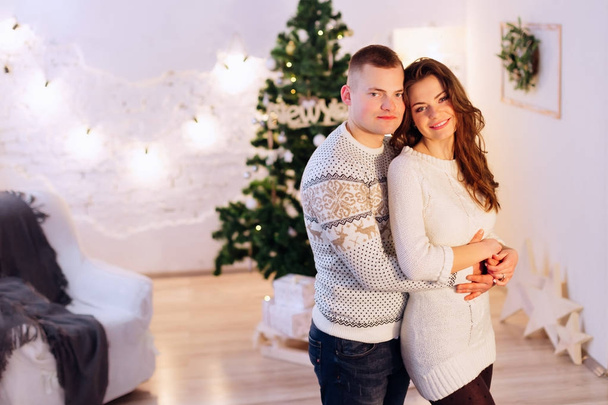 ευτυχισμένο ζευγάρι στο λευκό δωμάτιο με χριστουγεννιάτικα στολίδια - Φωτογραφία, εικόνα