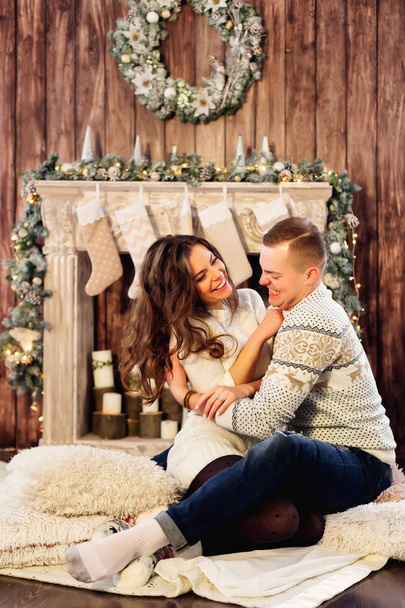 Beautiful stylish couple having fun near fireplace decorated for - Φωτογραφία, εικόνα