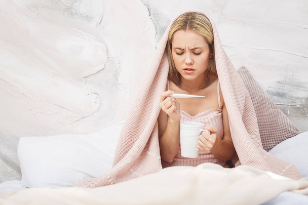 Mujer enferma acostada en la cama con fiebre alta. Resfriado, gripe, fiebre y migraña
 - Foto, Imagen