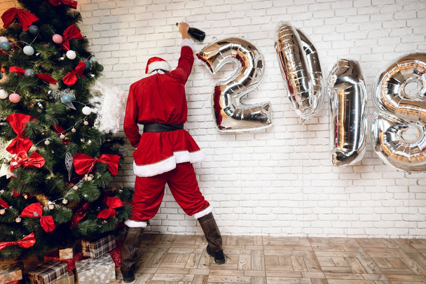 Drunk Santa Claus urinate under the New Year tree after a tumultuous party. He hardly stands on his feet. - Photo, image