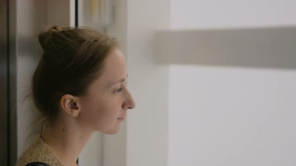 Young woman looking around in elevator - Кадри, відео