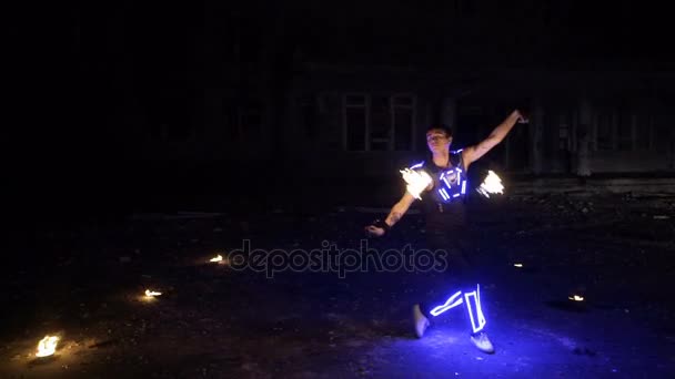 Boy shows different tricks with burning pois rotation at evening fire show. - Footage, Video