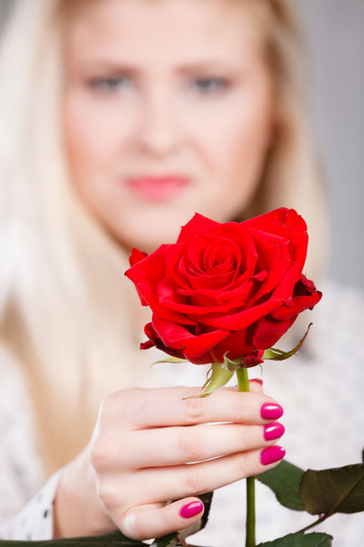woman holding red rose in hand - Фото, зображення