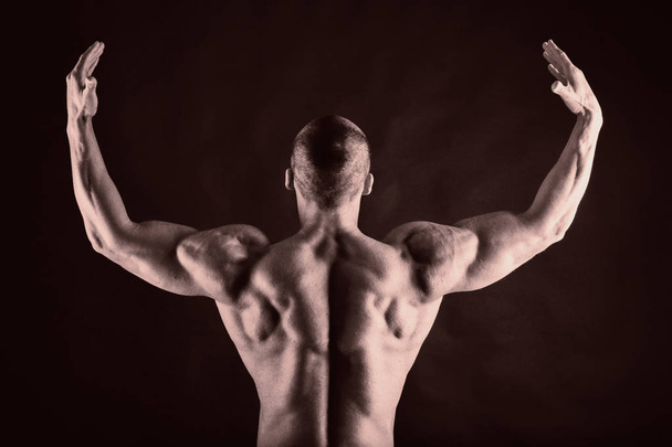 bodybuilder op zwart - Foto, afbeelding