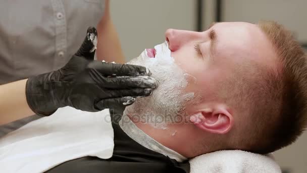 Close-up gezicht van een man verspreid scheerschuim. Barber, barbershop. - Video