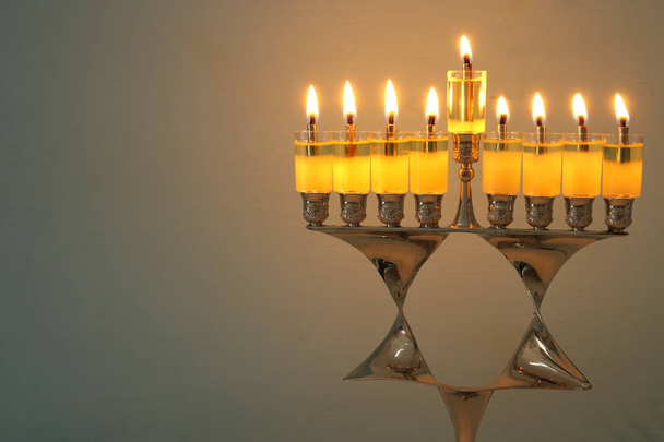image of jewish holiday Hanukkah background with menorah (traditional candelabra) and burning candles. - 写真・画像