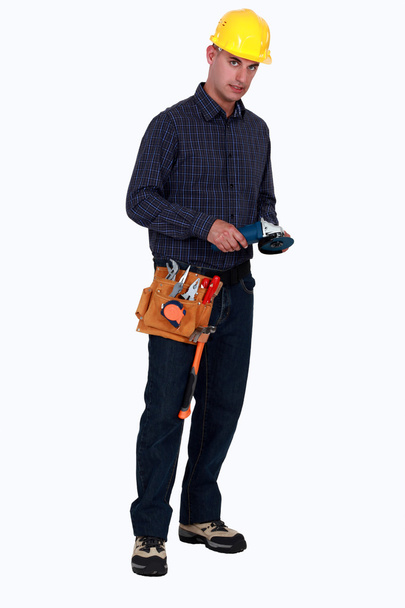 Craftsman holding a little electric saw - Fotoğraf, Görsel